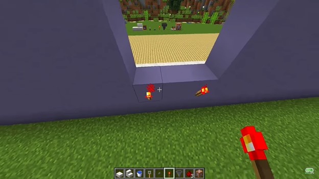 Redstone torches on a wall in Minecraft